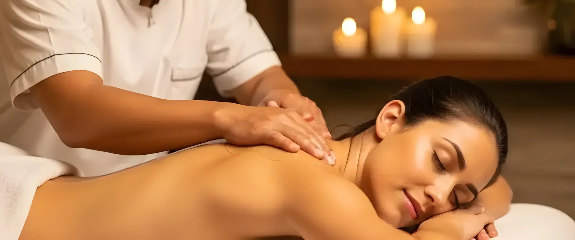 Spa therapist providing shoulder massage to woman with calm ambiance.